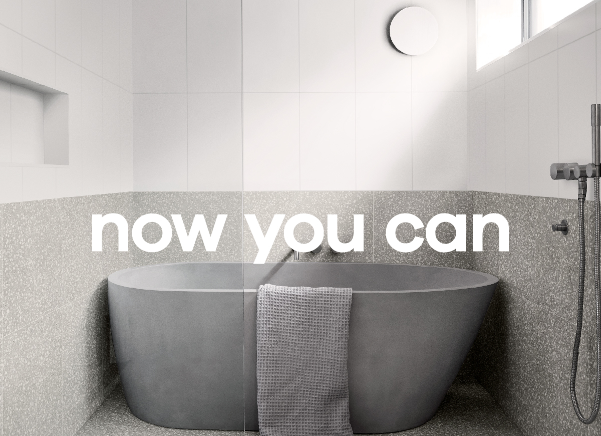 Grey Stone Bath in white tiled bathroom with Now You Can text for National Tiles advertising campaign