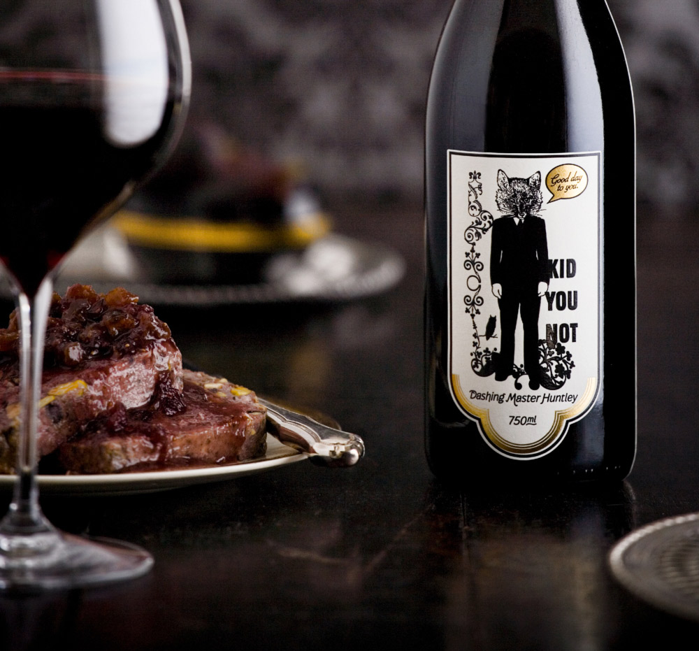 kid you not brand packaging red wine label on table with steak and glass